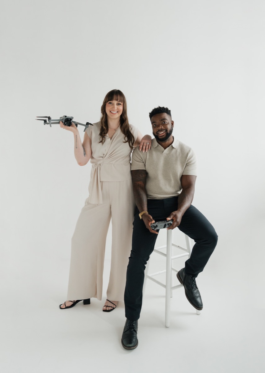 Keanna holding a drone and Leonard holding the controller in a studio portrait