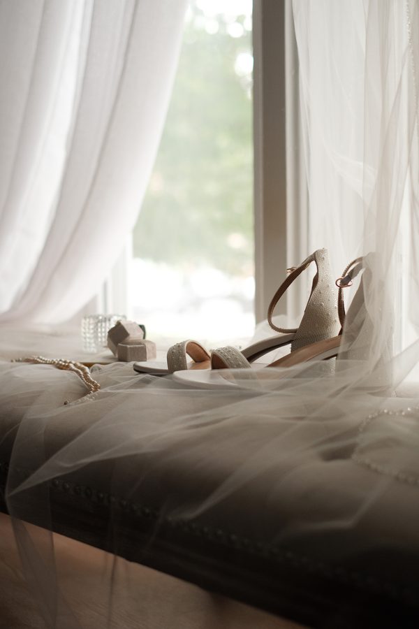 Bride's shoes and ring box in soft window light