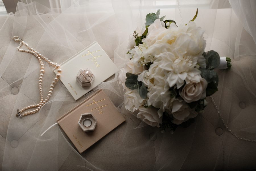Invitation, ring box, pearls and bouquet flat lay