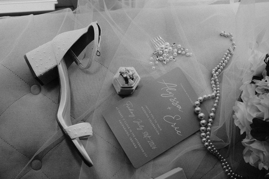 Black and white detail of the invitation, shoe and ring box
