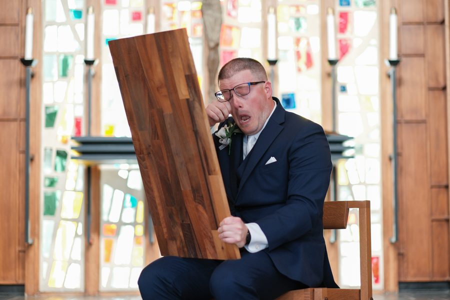 Eric wiping away tears behind the engraved board