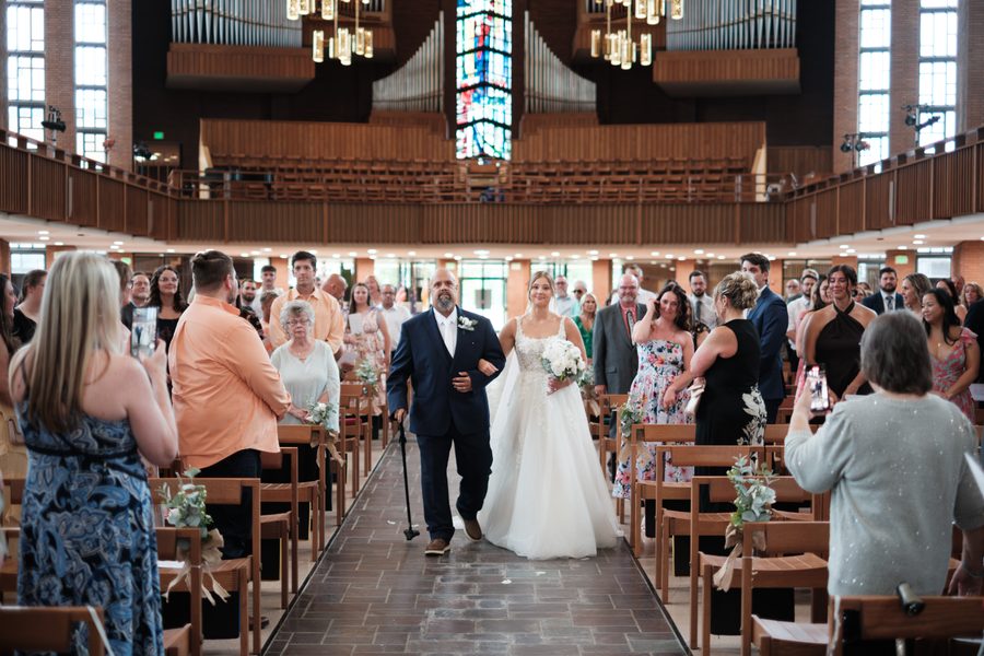 Alyssa walking down the aisle of the chapel