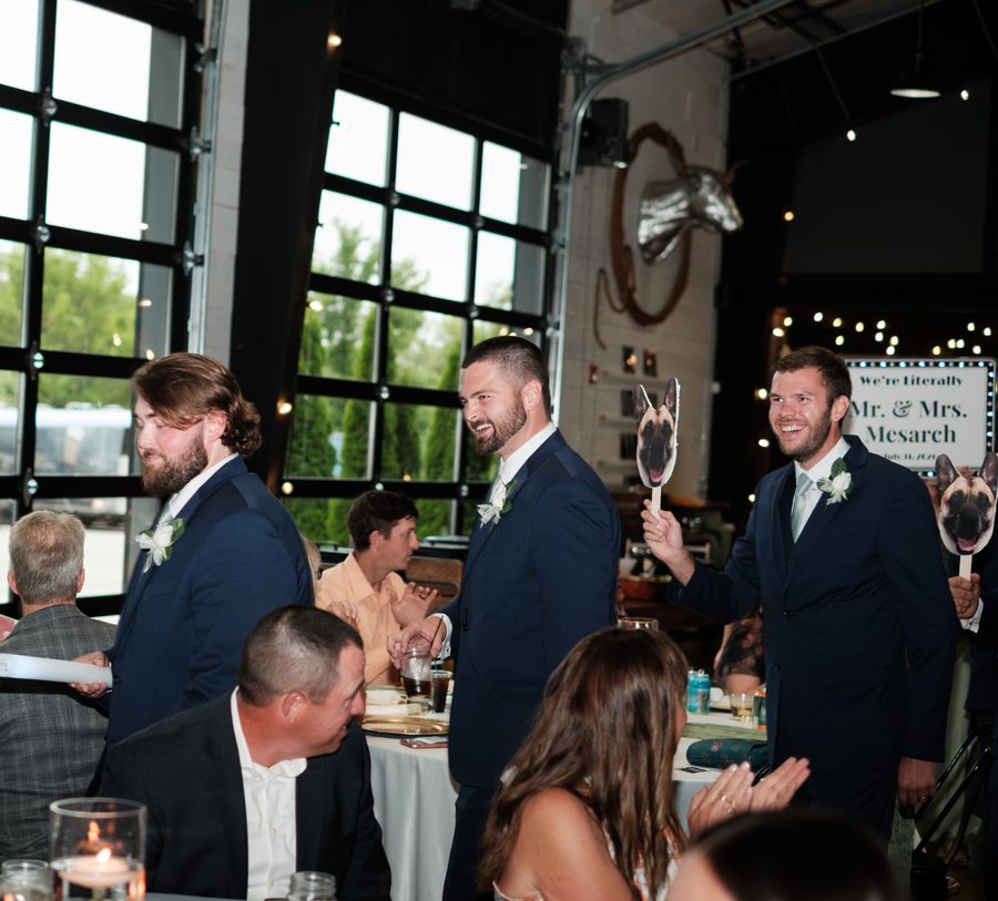 Groomsmen cheering with Tito signs during the grand entrance
